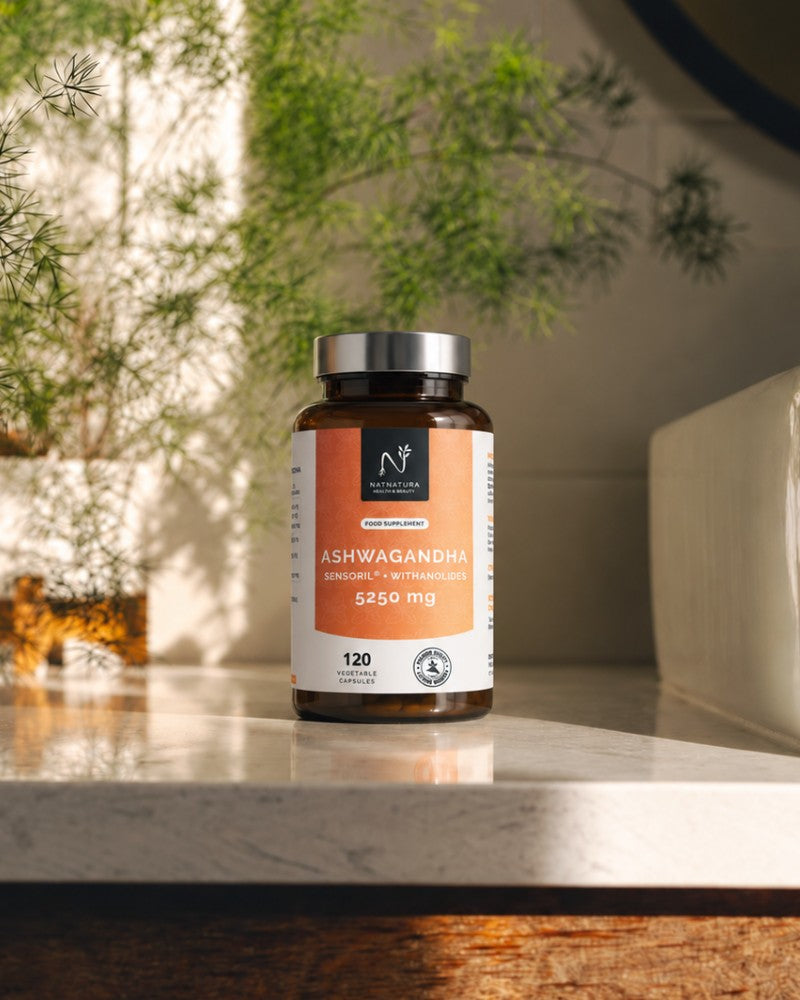 Bote de Ashwagandha de Natnatura sobre la encimera de un baño, junto a una planta